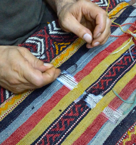 Man Repairing Handwoven Kilim Rug